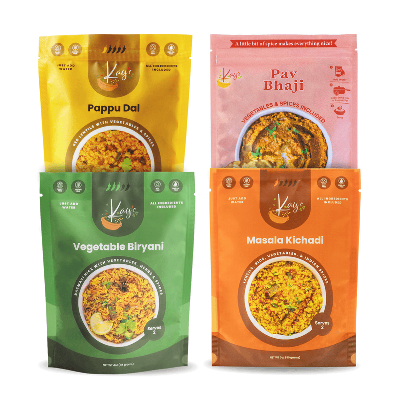 Four stand-up pouches of Kay's Curries Indian Meal Kits arranged in a 2x2 grid on a white background. The packages are yellow for Pappu Dal, pink for Pav Bhaji, green for Vegetable Biryani, and orange for Masala Kichadi.