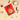 Red package of 'Chicken Biryani' with rice, spices, and a bowl of biryani on a beige background